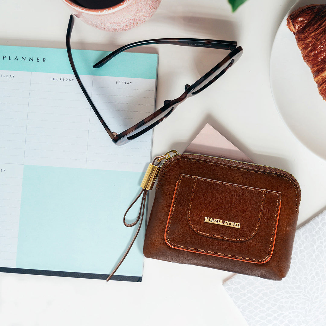 brown_coin_holder_Marta_Ponti_on_top_of_a_desk_with_planner_and_glasses